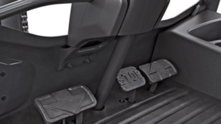 Kolme poljinta: Vasemmassa polkimessa on taaksepäin osoittava nuoli, oikeassa polkimessa on eteenpäin osoittava nuoli, ja keskimmäisessä polkimessa on sana ”Stop”