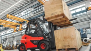 Electric forklift truck transporting heavy crates