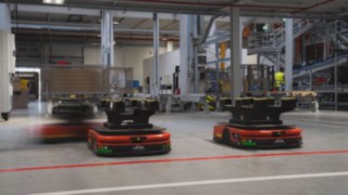 Kolme Linde MH:n itsenäistä mobiilirobottia (AMR) ajaa varastossa.
