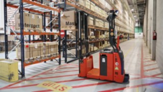 Automaattinen L-MATIC AC -pinontatrukki Schneider Electricin logistiikkakeskuksessa