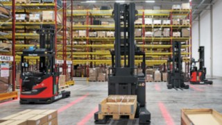 Linde MH:n R-MATIC-koneita odottamassa seuraavaa ajotehtävää hyllyn edessä.