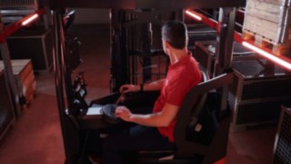 Kuljettaja Linde MH:n Ri16-työntömastotrukin ergonomisessa työtilassa.